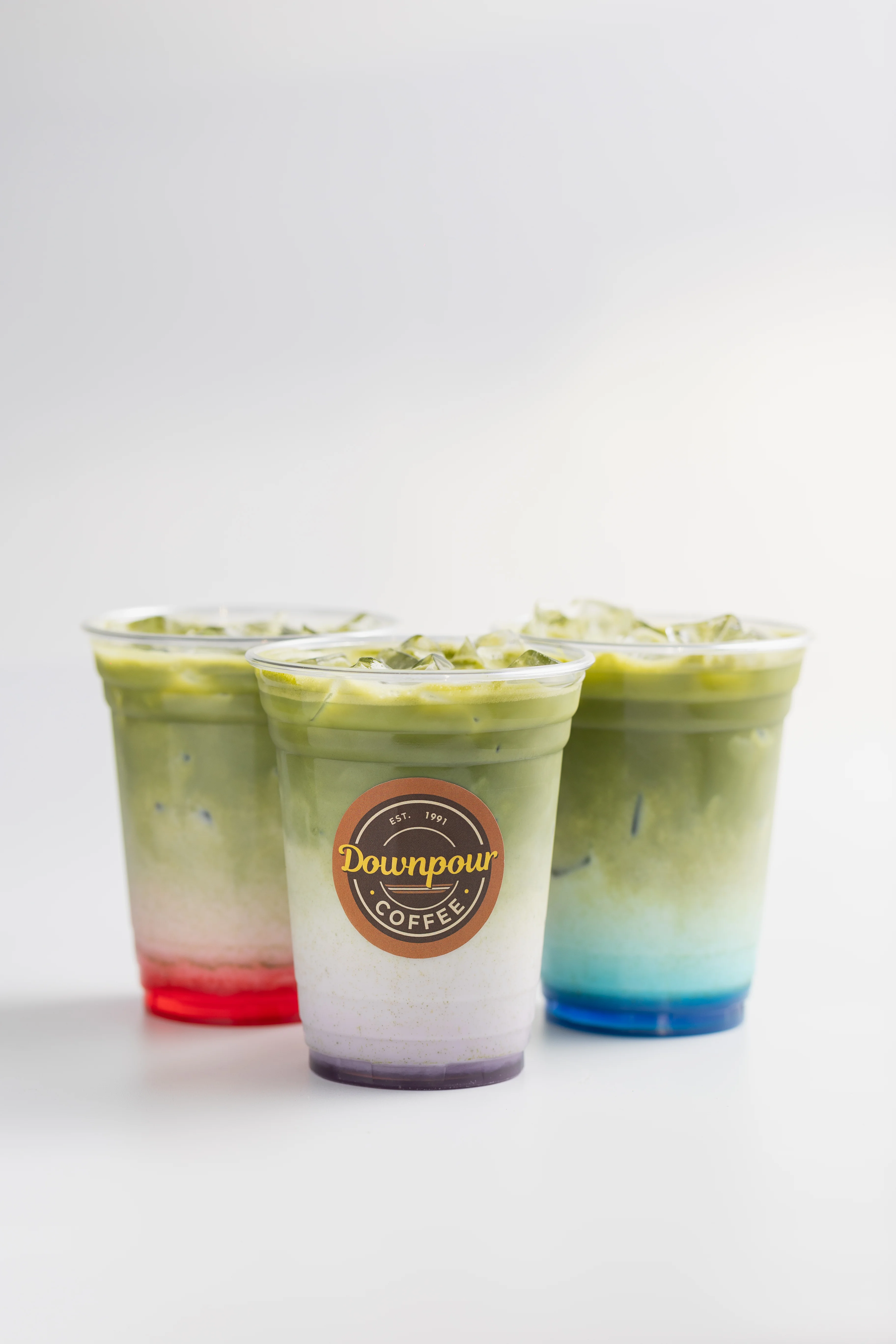 Colorful matcha drinks in clear cups from Downpour Coffee