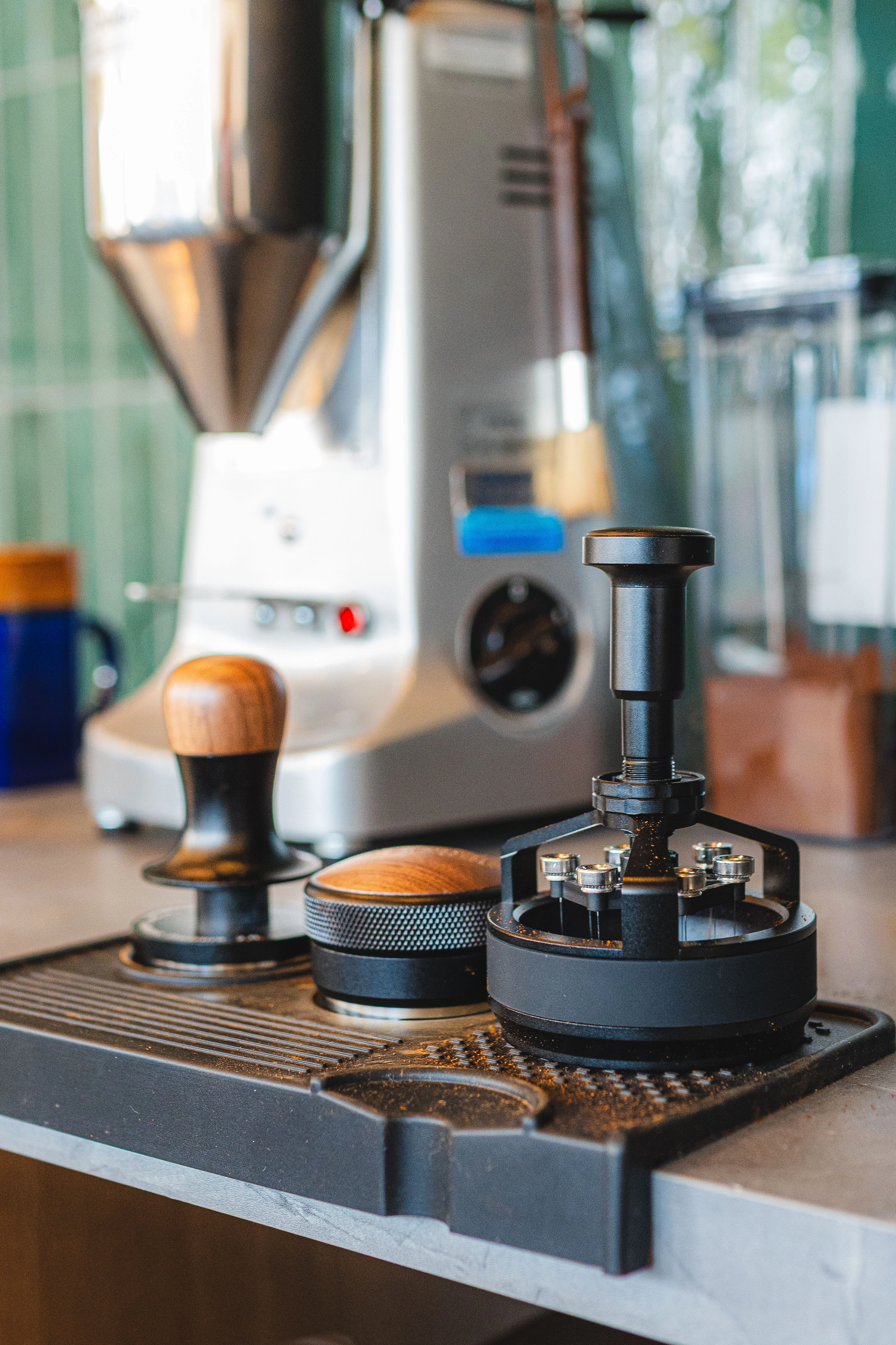 Coffee brewing equipment with a grinder and tamper on a countertop
