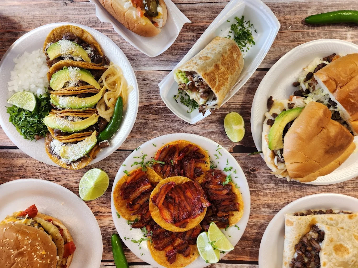 Assorted Mexican tacos and burritos on a rustic wooden table