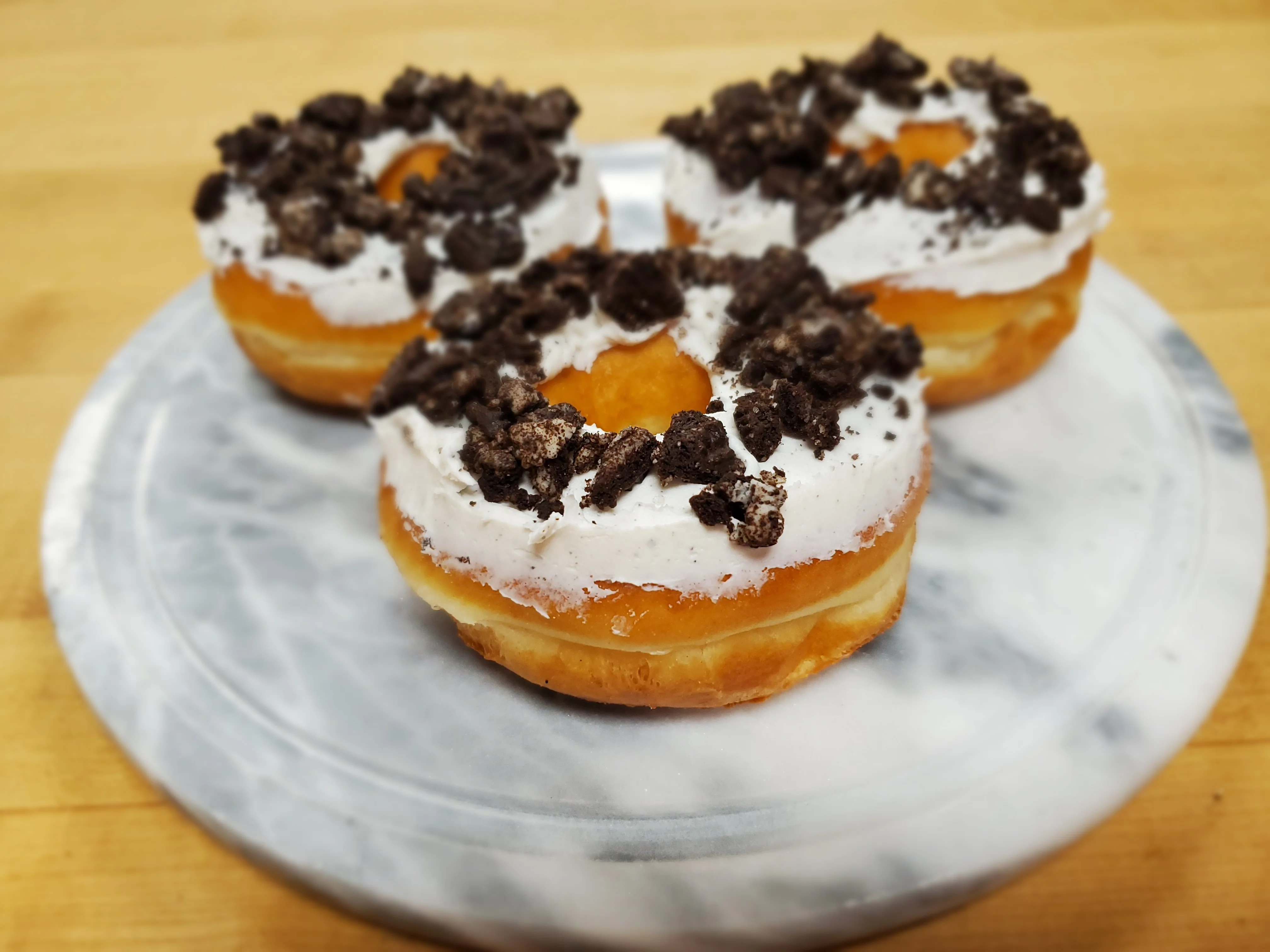 Decadent cookies and cream donuts on a marble platter