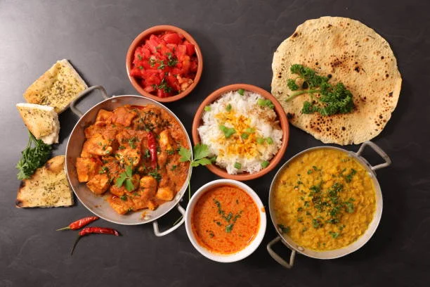 Indian thali with chicken curry, dal, rice, and naan