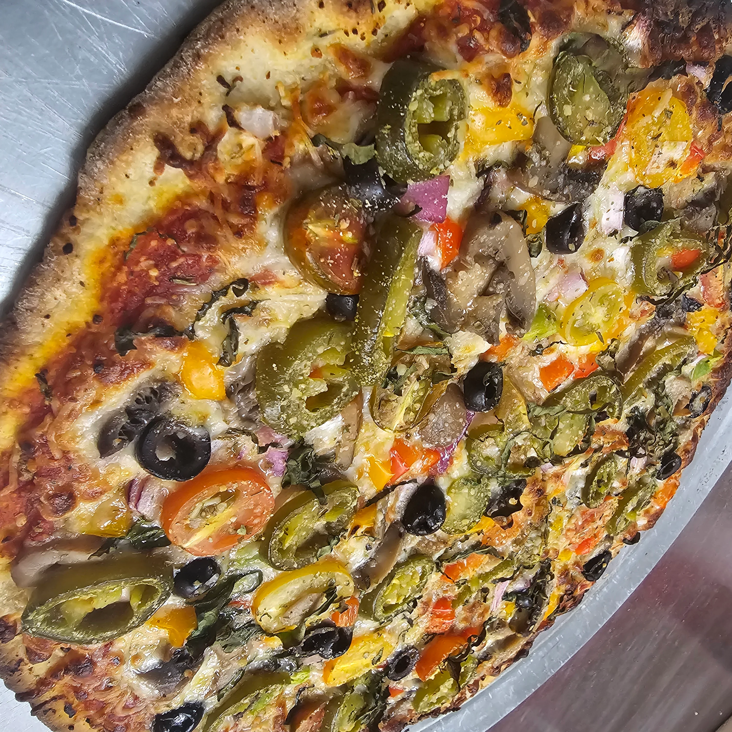 Vegetarian pizza with colorful toppings on a metal tray
