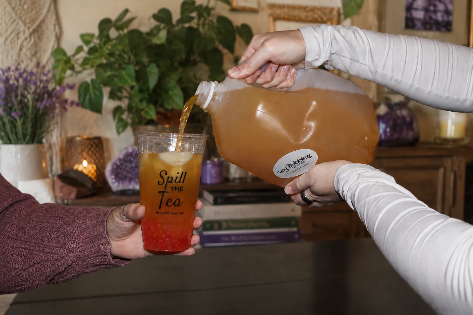 Pouring iced tea into a bubble tea cup at a cozy cafe