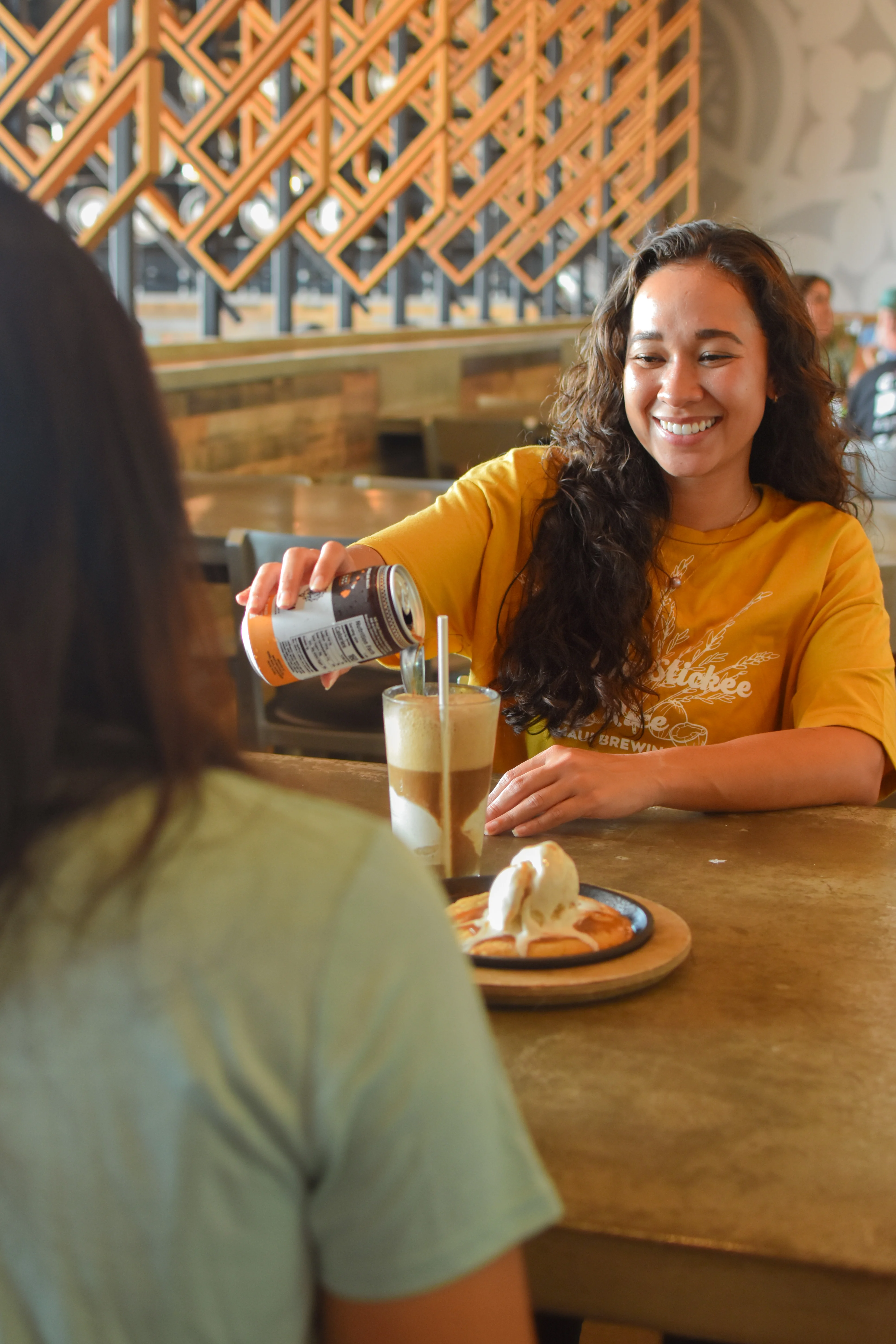 Woman pouring a drink in a cozy restaurant setting