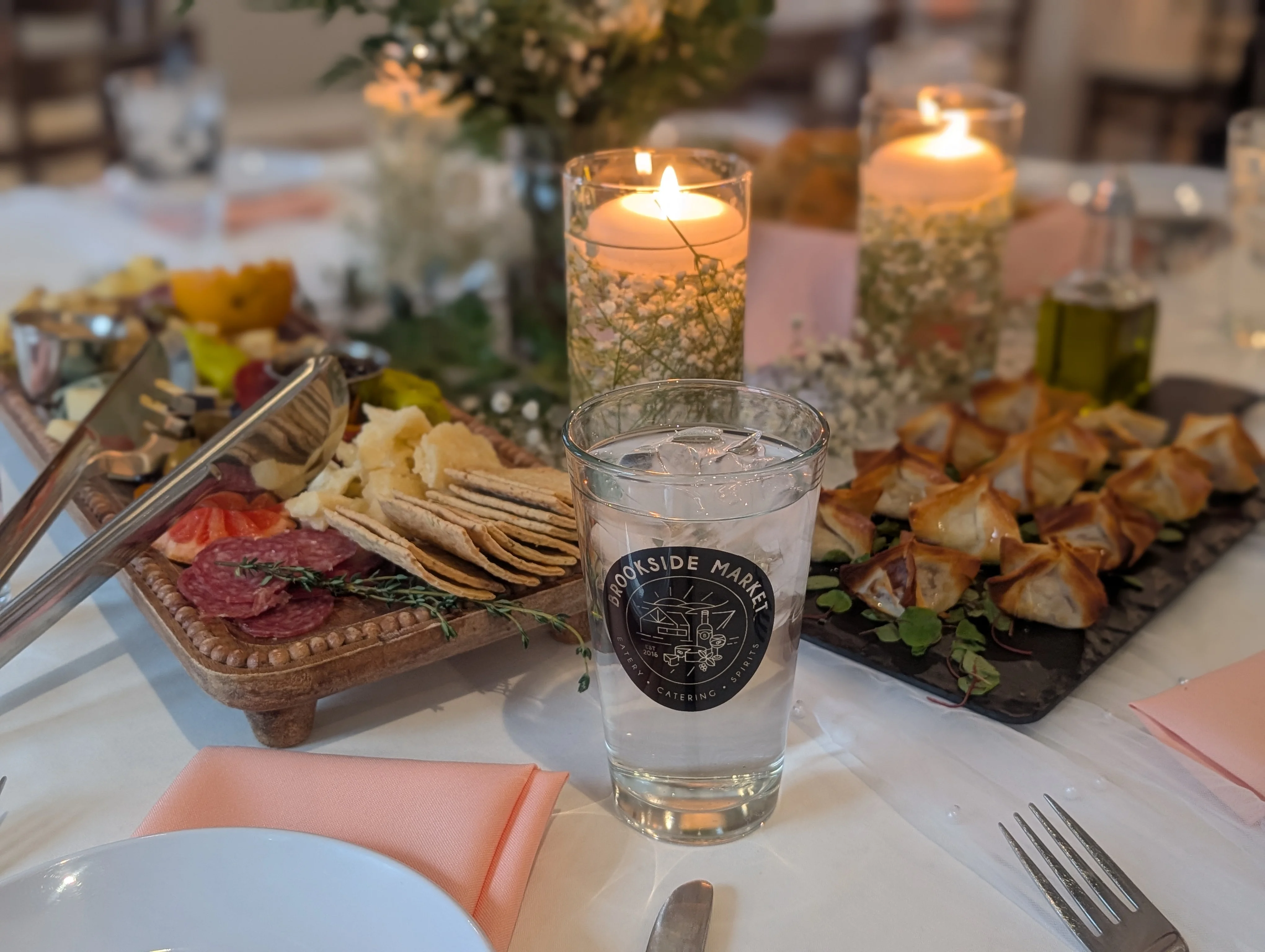 A beautifully arranged charcuterie board with drinks and candles.