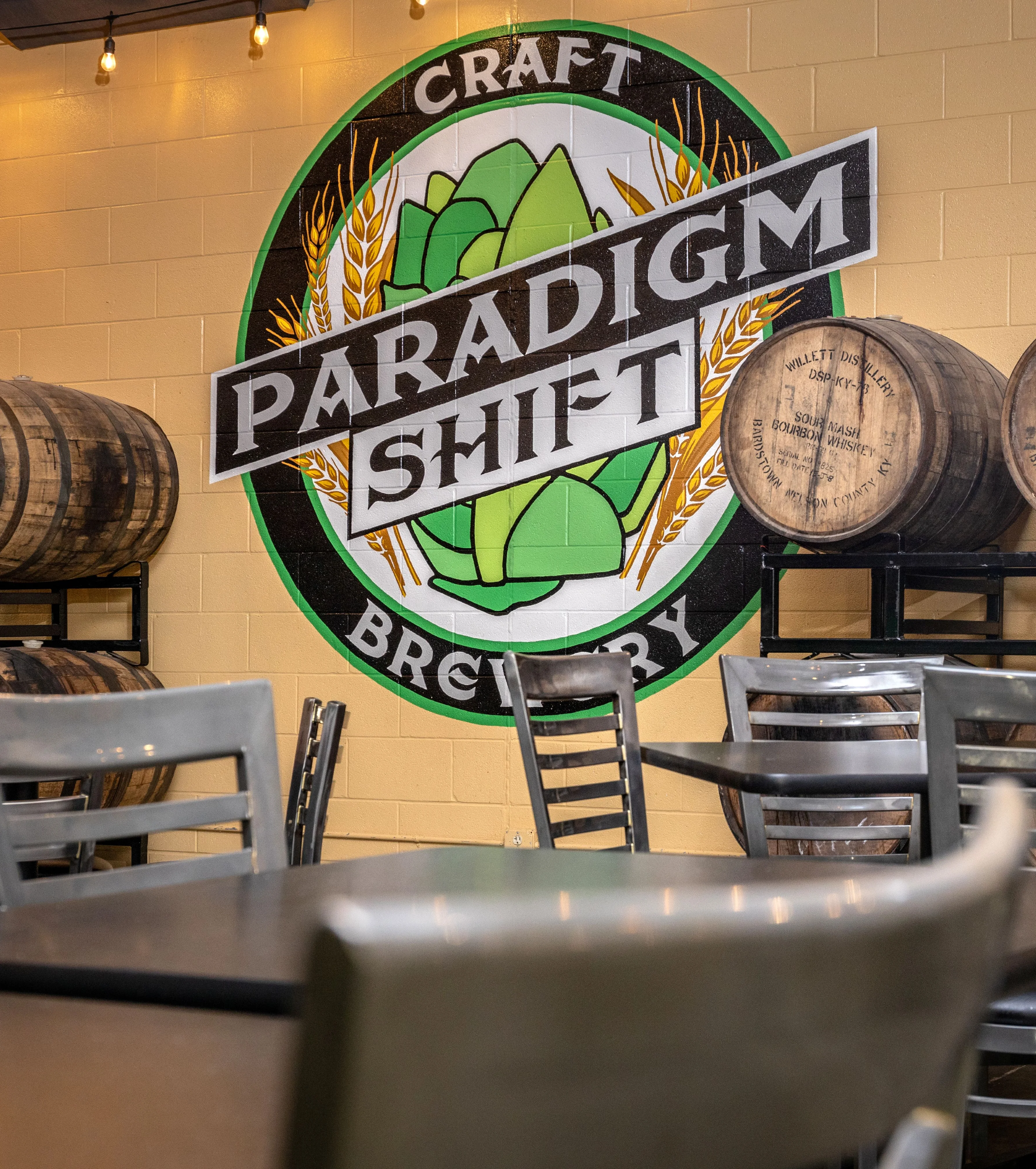 Craft brewery interior with barrels and mural