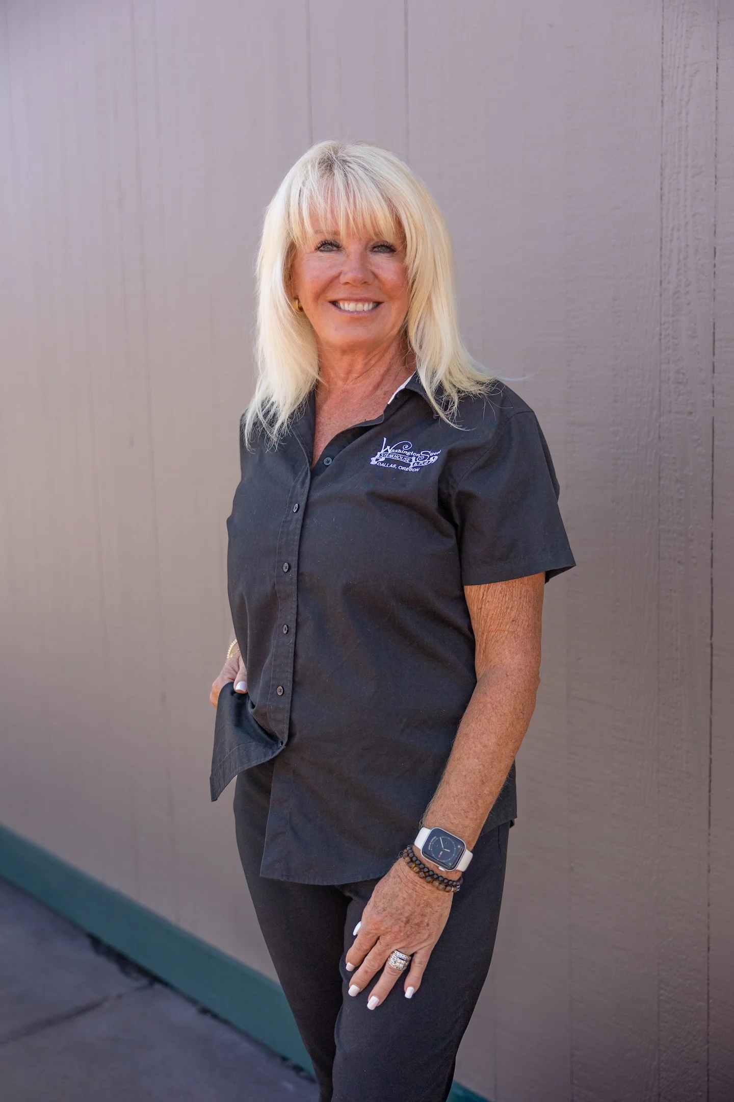 Restaurant staff member smiling in a black uniform