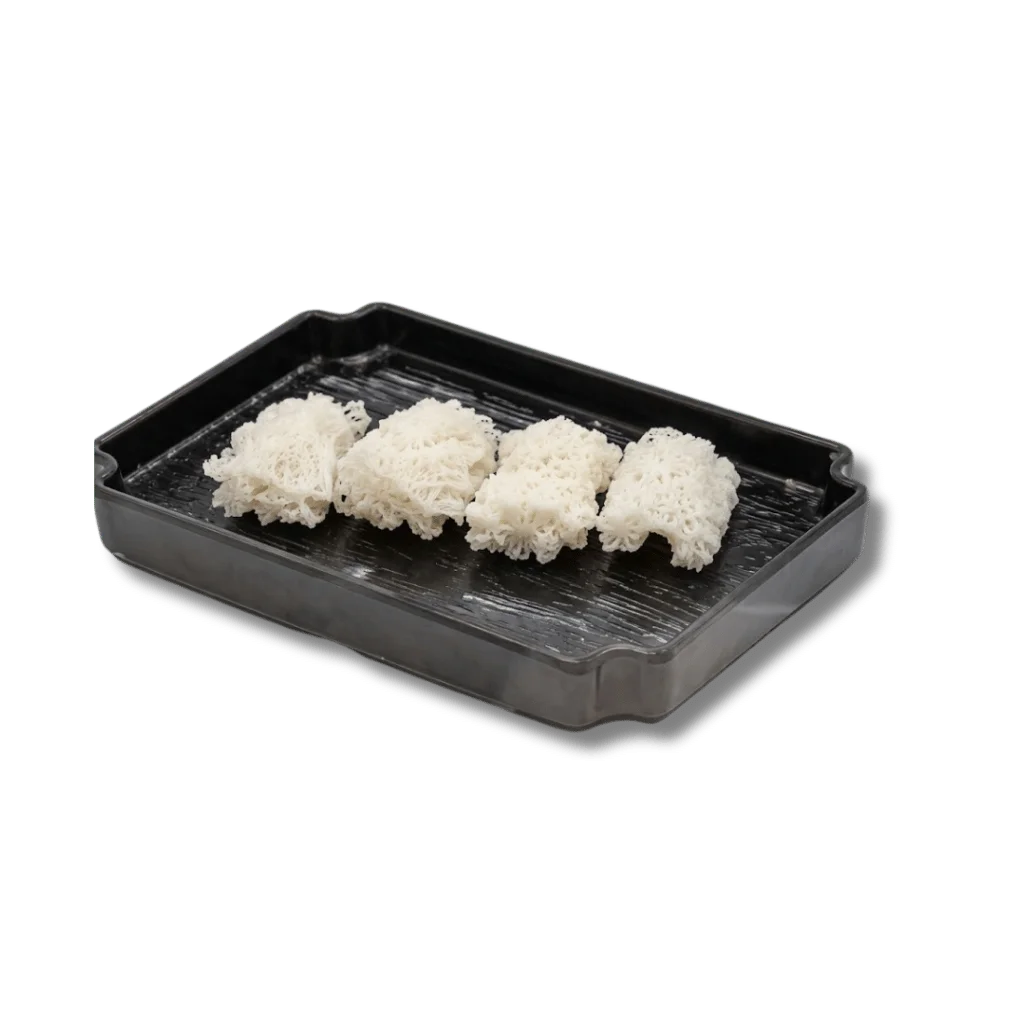 Three portions of delicate white noodles on a black serving tray.