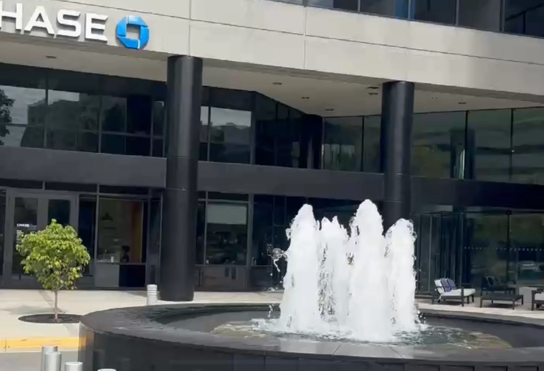 Modern office building with a fountain and greenery
