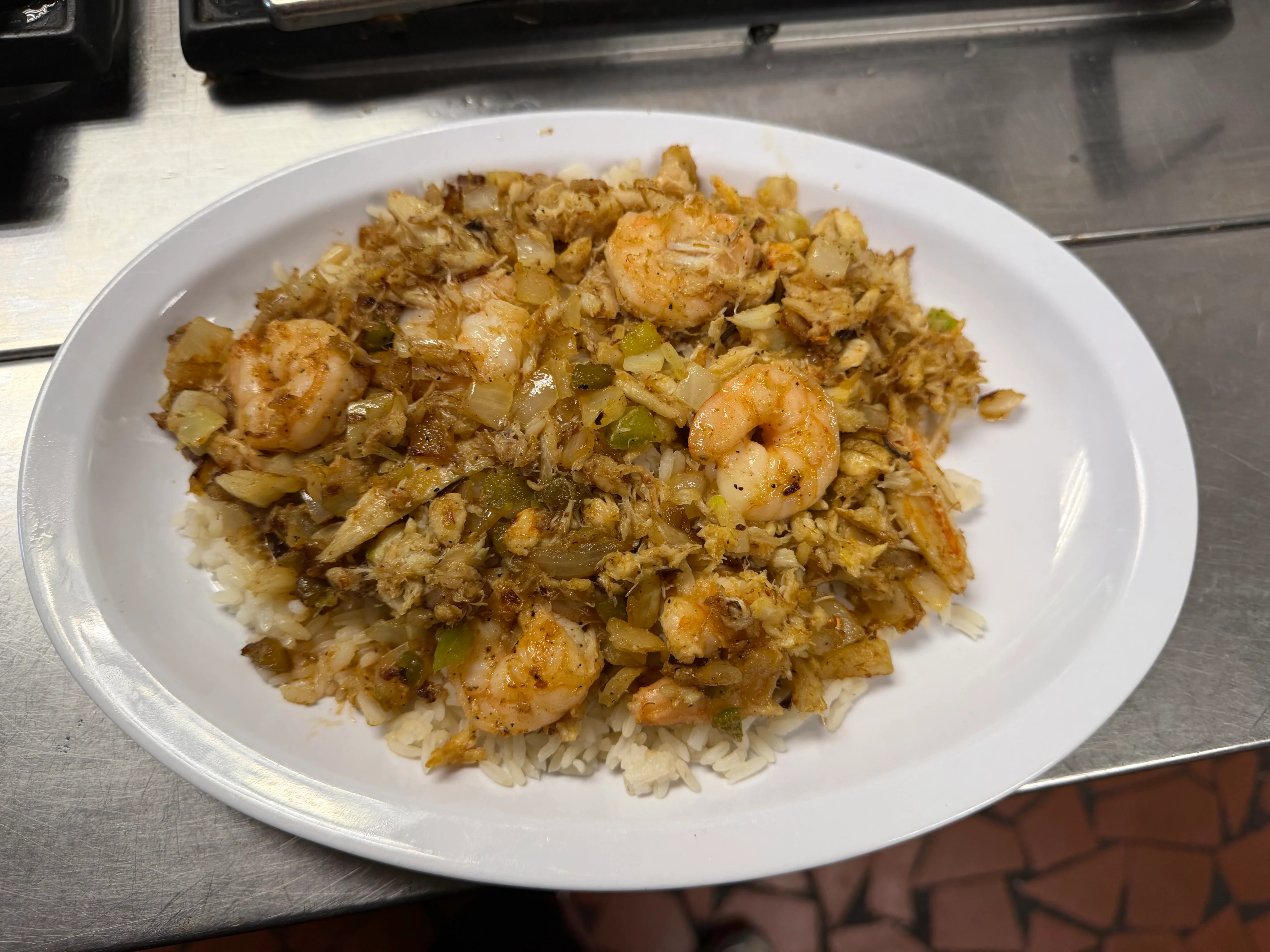 A hearty plate of meat and rice, featuring chopped meats and vegetables mixed with rice, garnished with green onions.