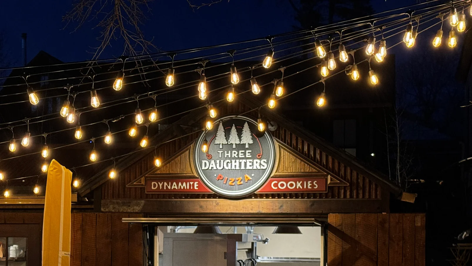 Three daughters Pizza building with logo above the takeout window