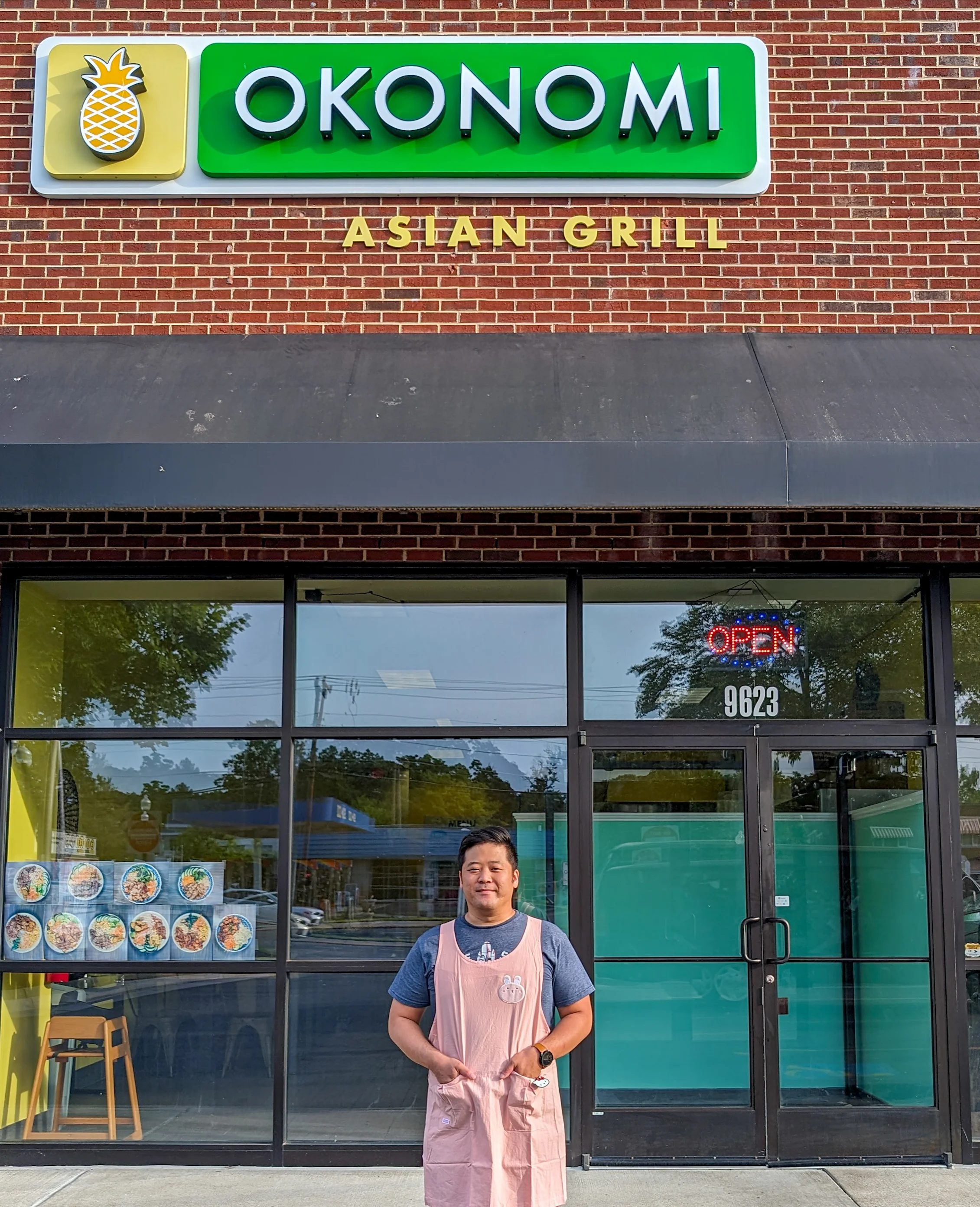 A restaurant chef standing in front of the restaurant
