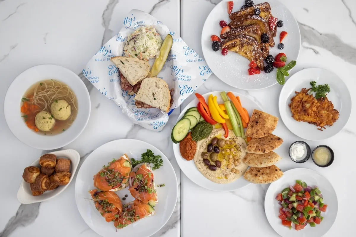 Assorted Jewish deli dishes including matzo ball soup and smoked salmon bagel