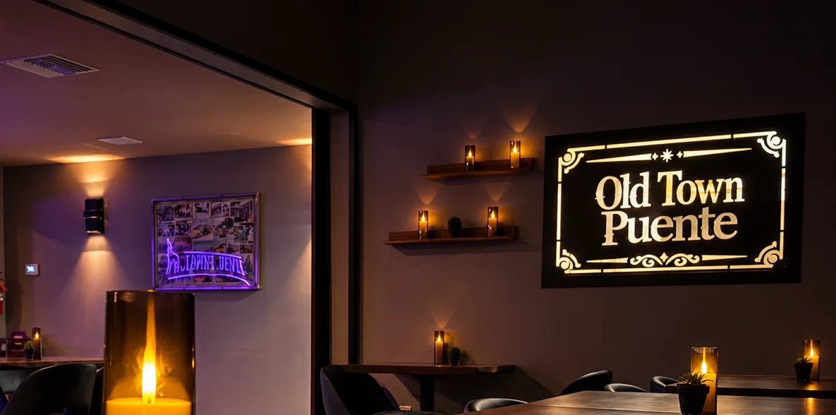 Warmly lit restaurant dining room with candlelit tables and wall signage