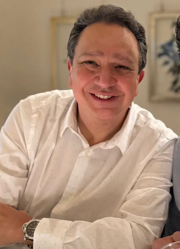 Smiling man in a white shirt at a restaurant table