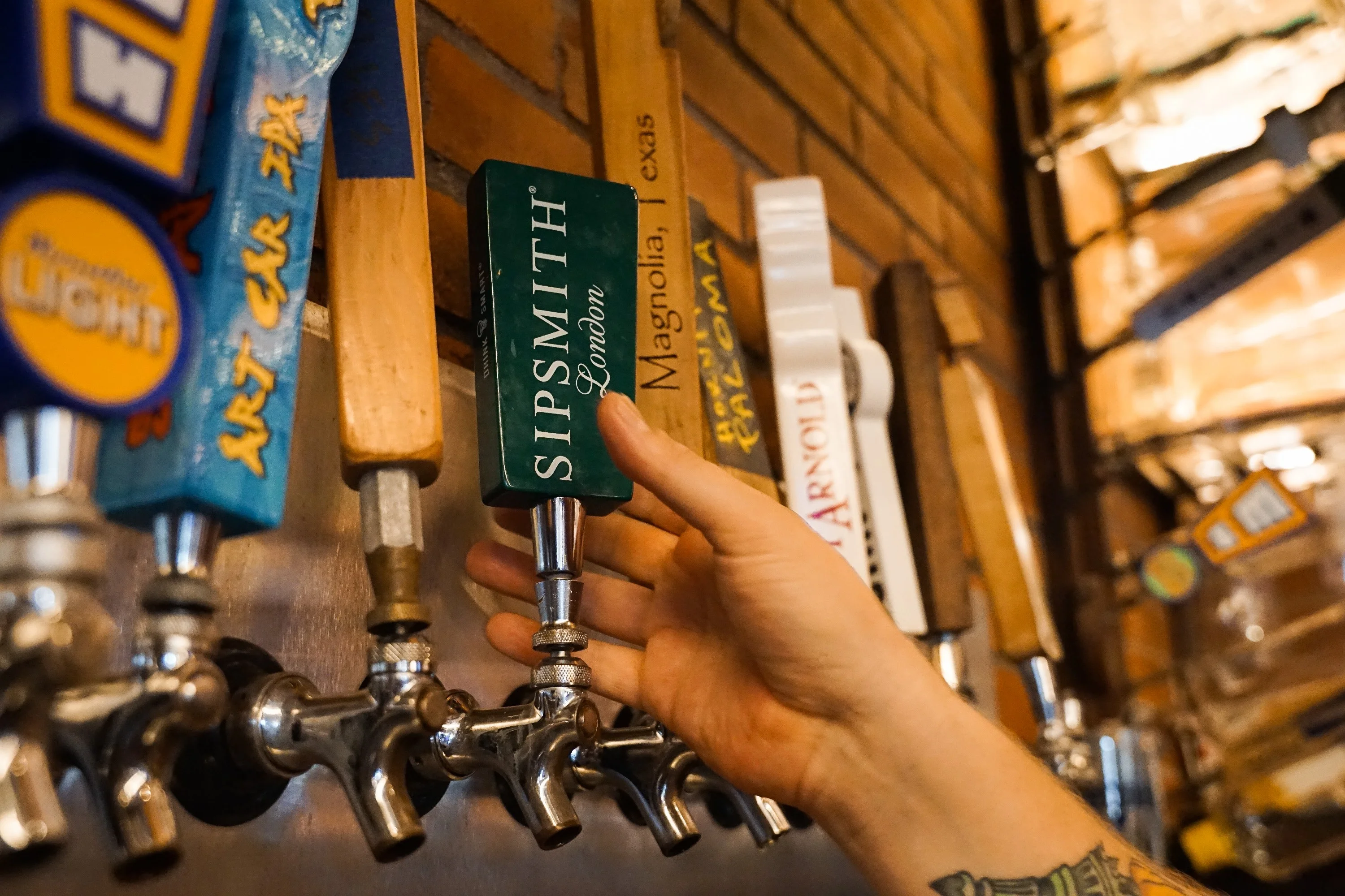Bartender pouring craft beer from a tap in a rustic bar