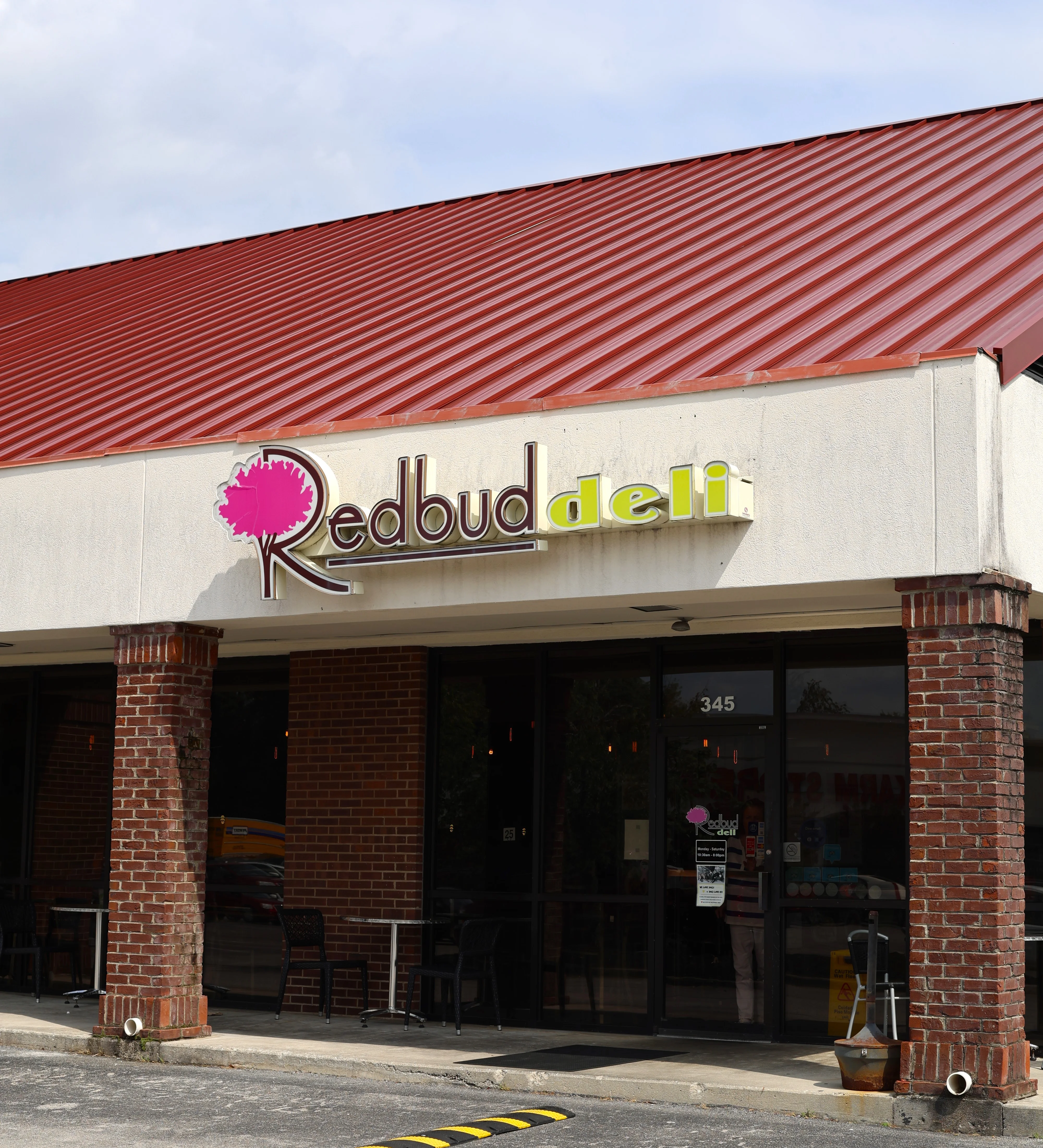 Exterior view of Redbud Deli with modern signage and outdoor seating