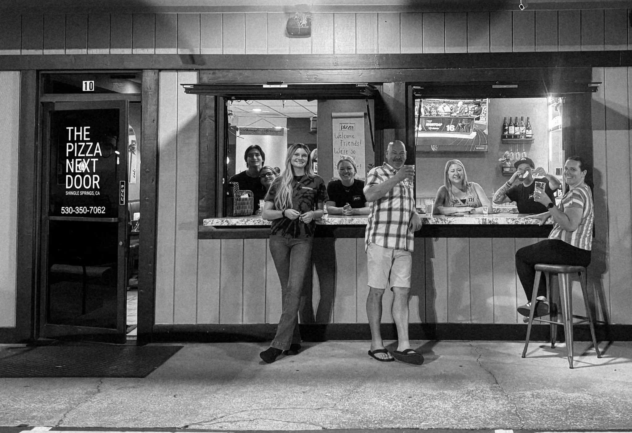 Child beside a freshly baked pizza in a restaurant kitchen