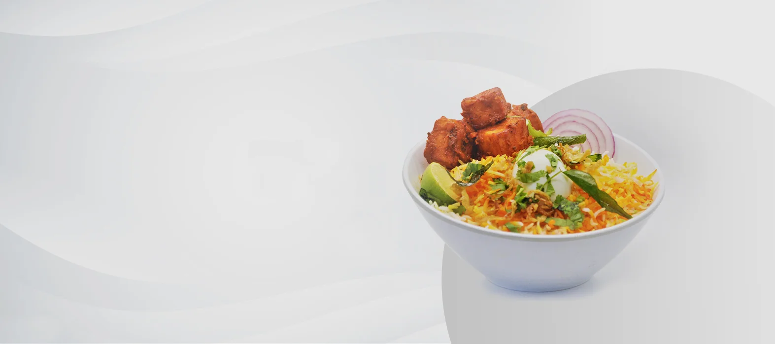 Bowl of Indian biryani with chicken and garnishes