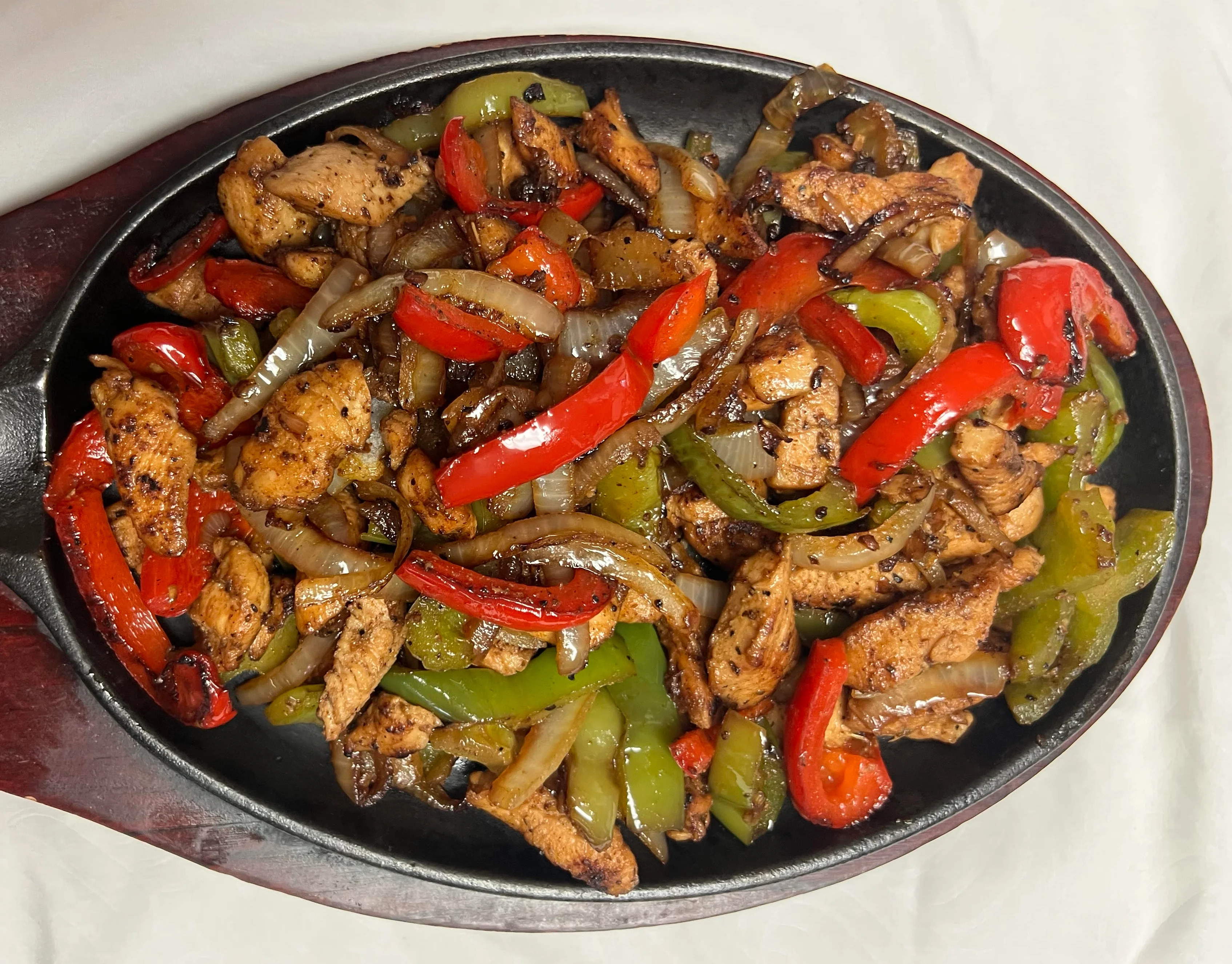 Delicious fajitas served with colorful vegetables and tortillas.