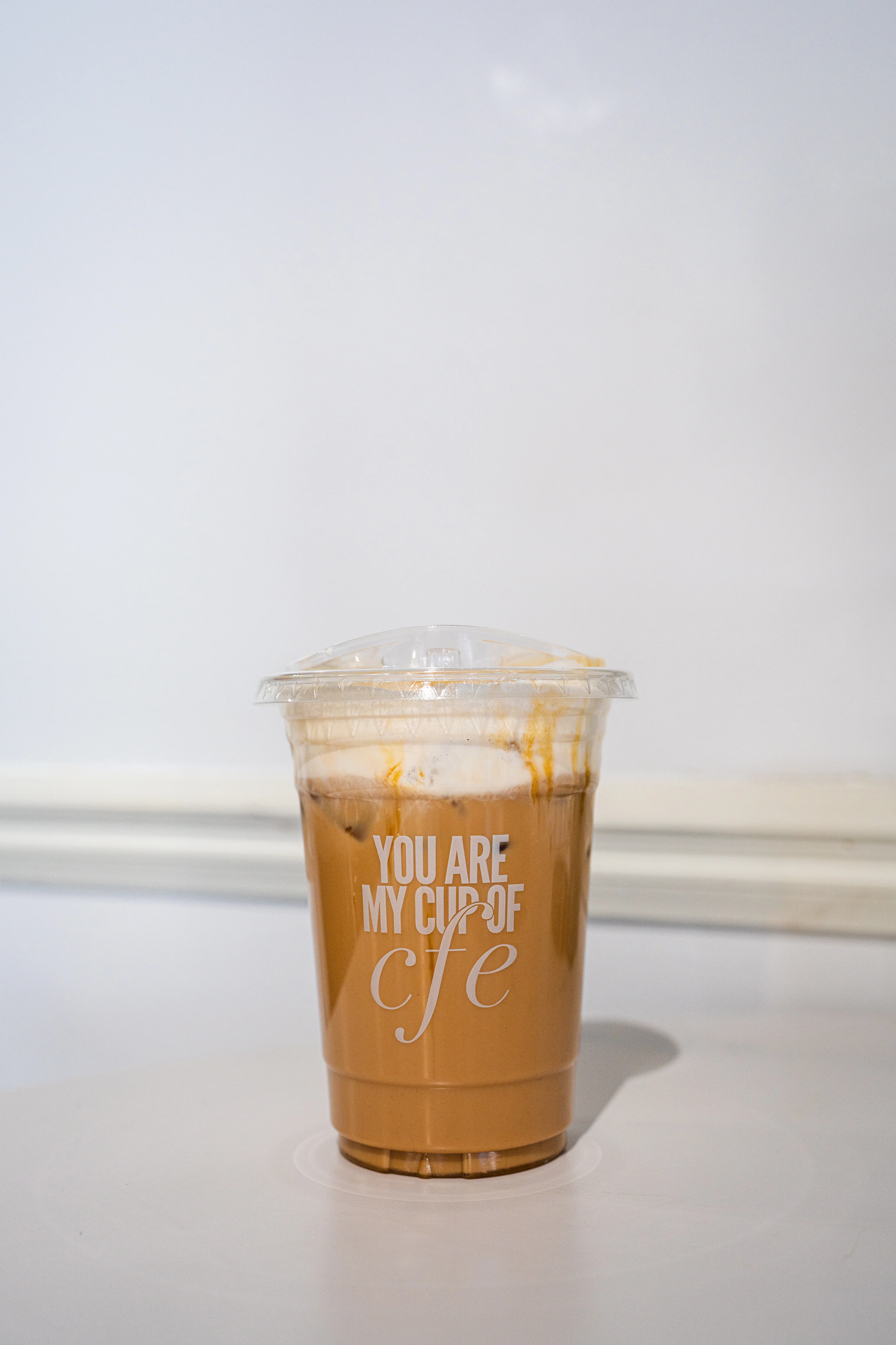 Iced coffee drink in a clear cup with a playful message