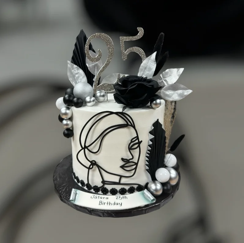Elegant birthday cake with black and silver decorations for a 25th celebration
