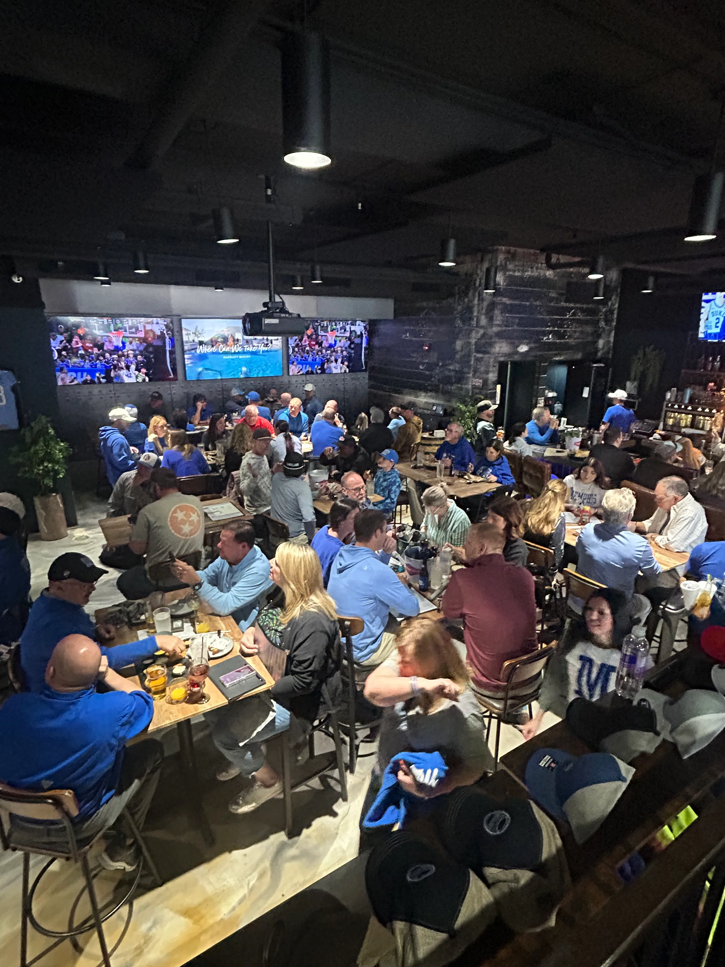 Lively restaurant interior with patrons enjoying food and drinks