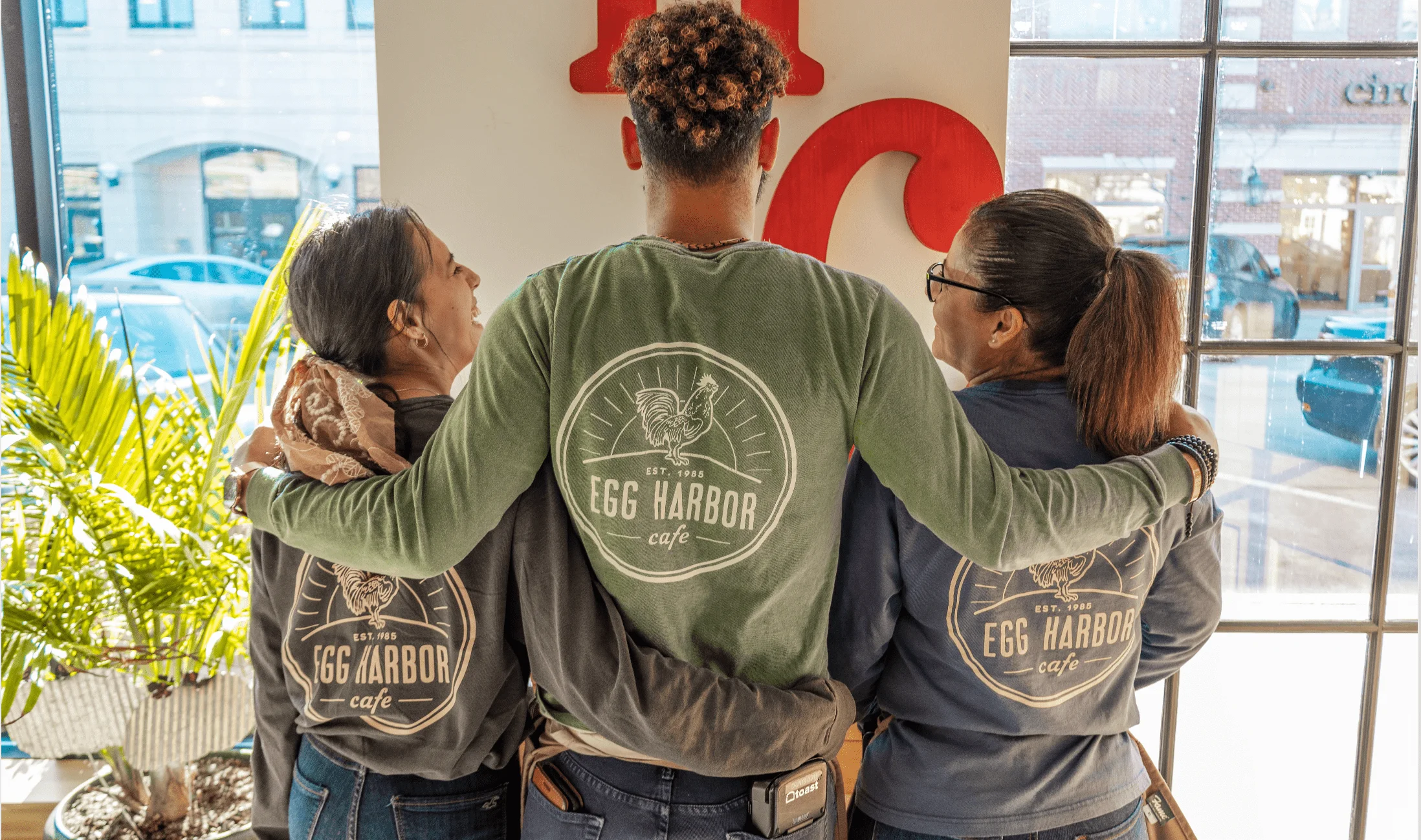 Staff members at Egg Harbor Cafe showcasing their branded apparel