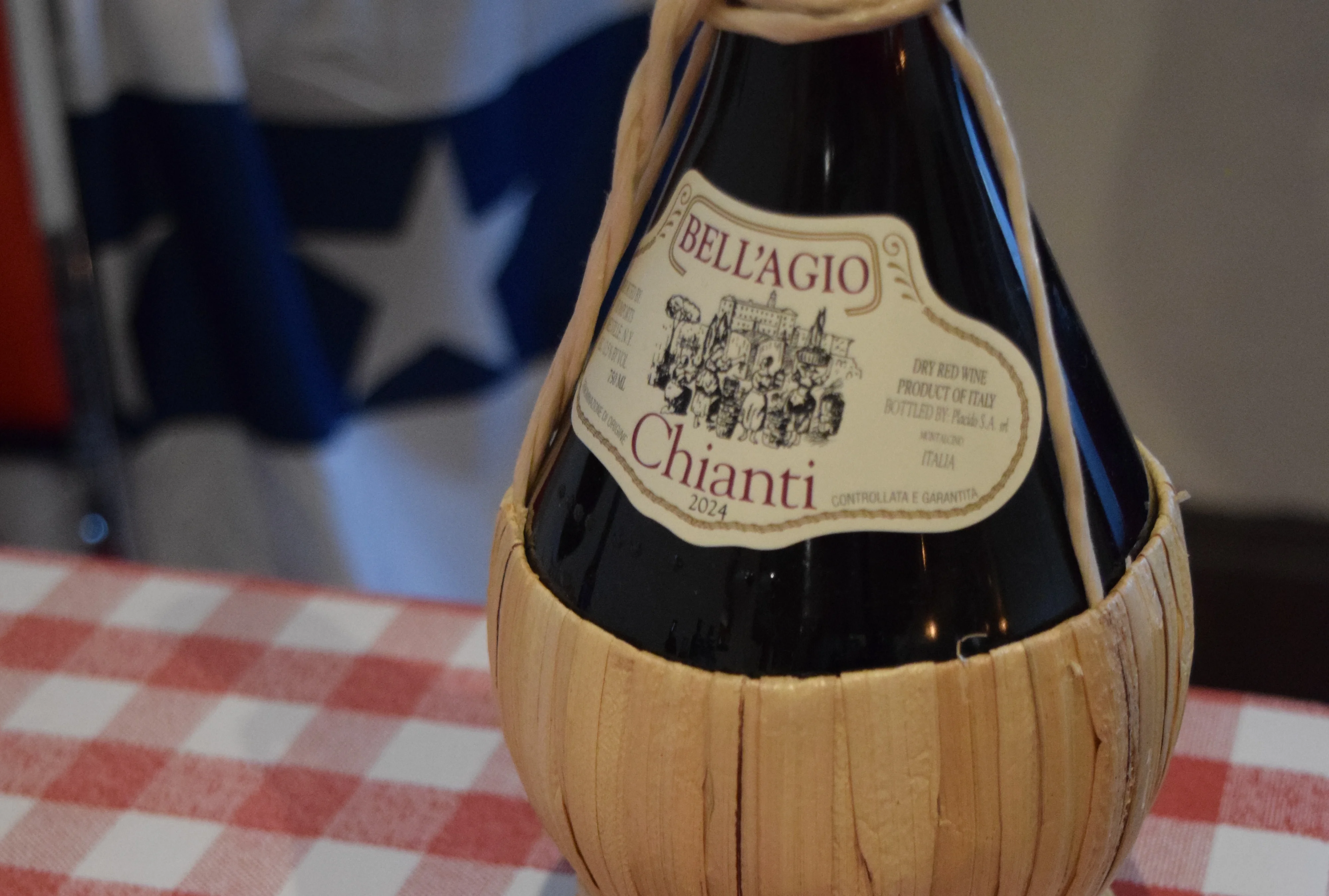 Bottle of Chianti wine with sunglasses on a checkered tablecloth