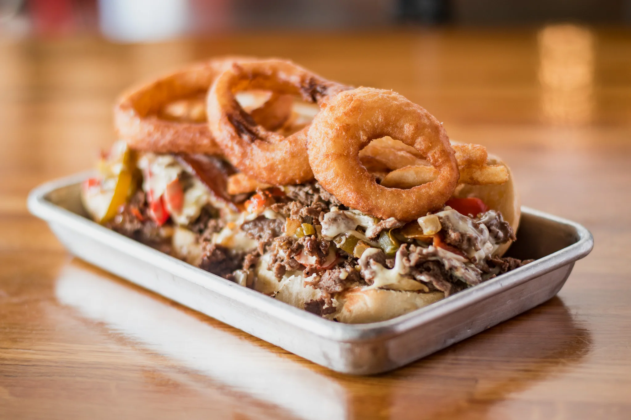 Philly cheesesteak sandwich with onion rings