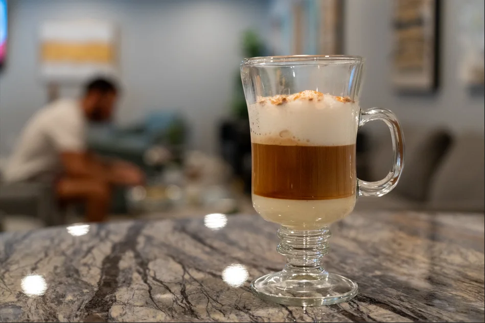 Layered latte with frothy milk and cinnamon topping