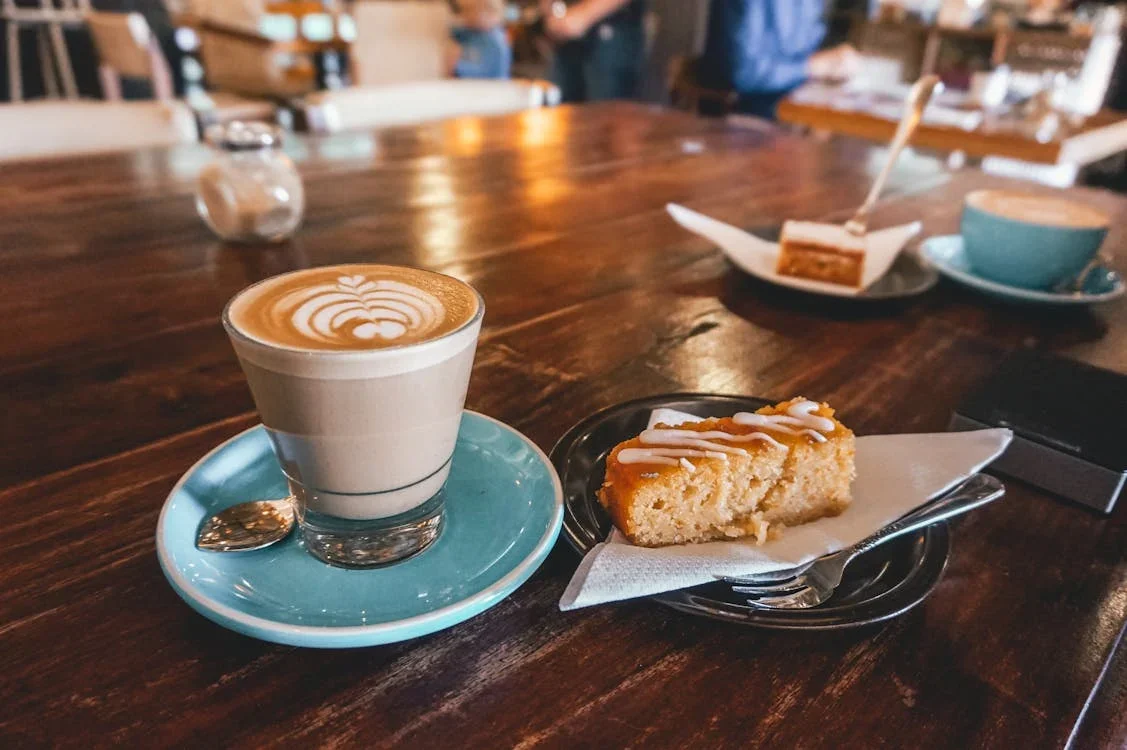 A cup of coffee with a side of baked goods