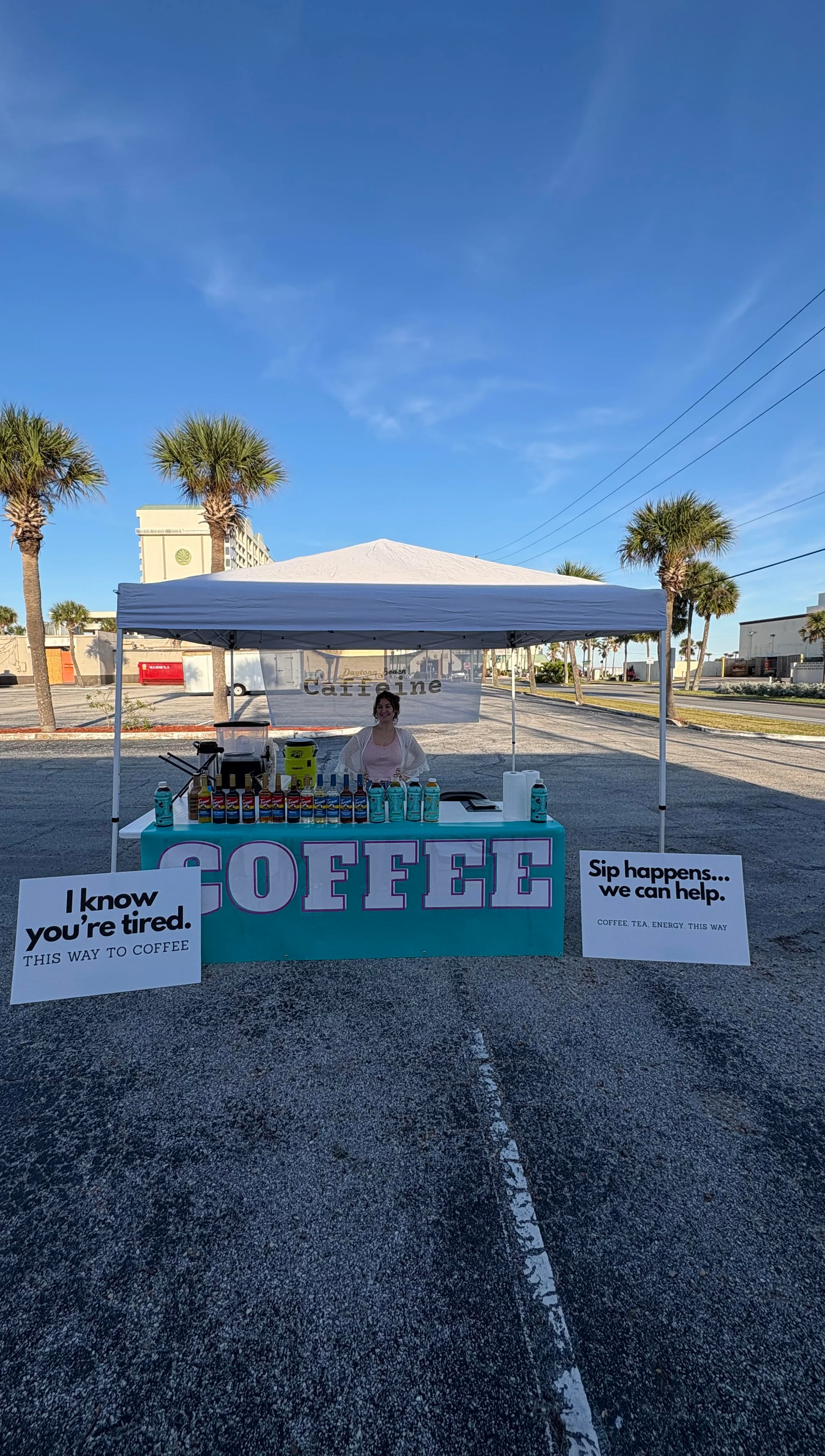 Coffee stand with signs inviting customers in a sunny outdoor setting