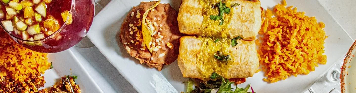 Colorful Mexican feast with enchiladas, rice, and grilled vegetables