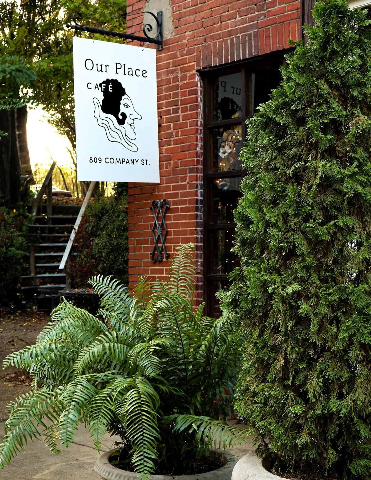 Charming café exterior with greenery and a sign