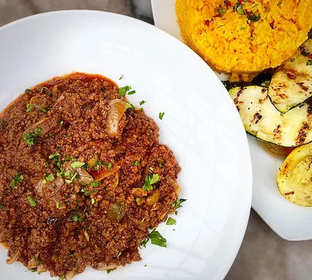 Savory Mexican picadillo served with yellow rice and grilled zucchini