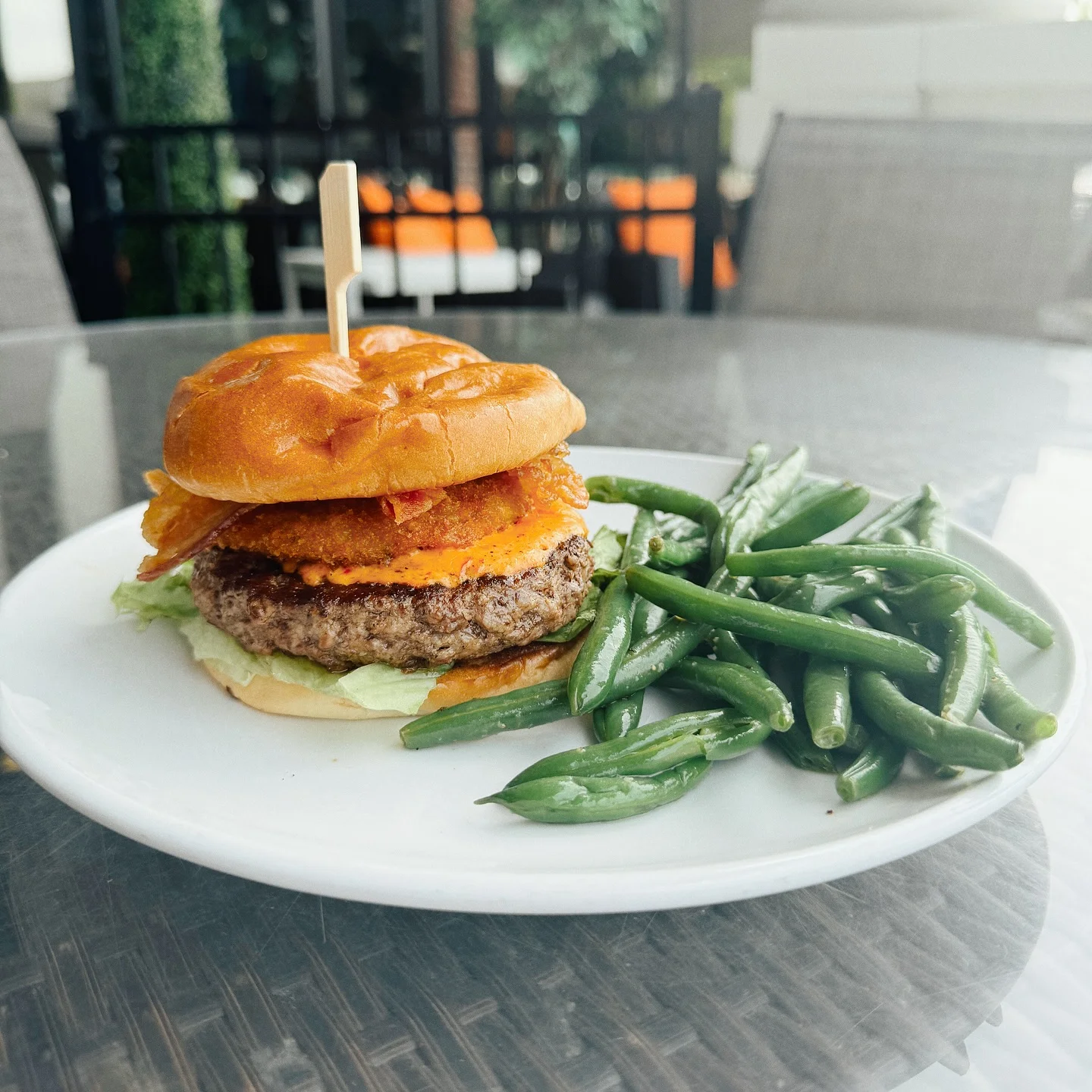 Juicy cheeseburger with crispy bacon and green beans