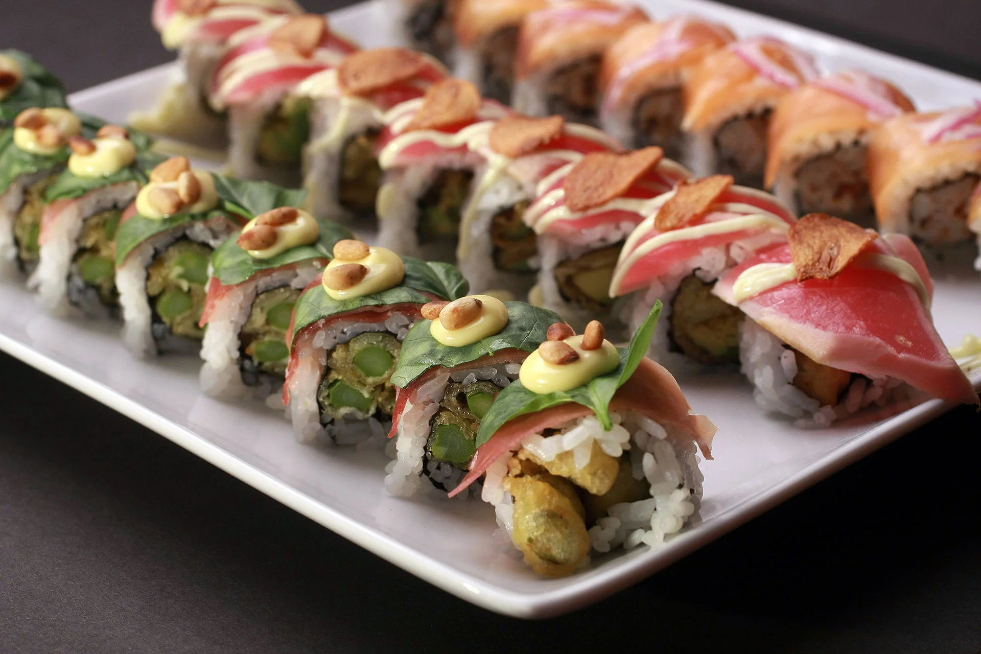 Artfully arranged sushi rolls on a white platter