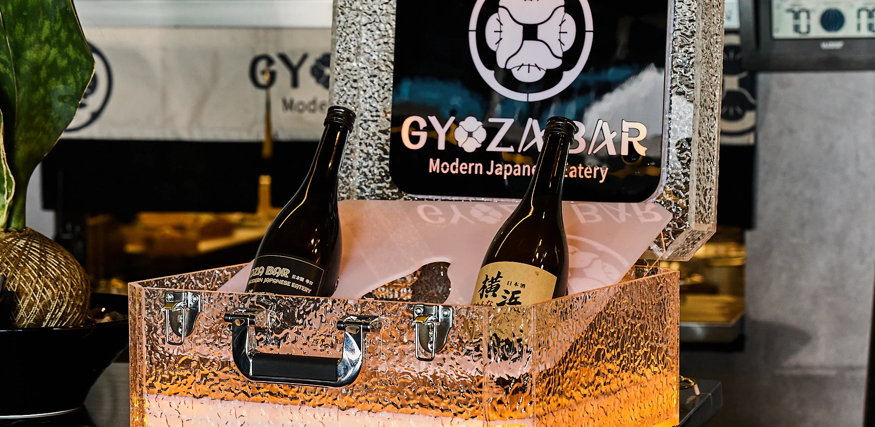 Japanese sake bottles in a stylish display case at a modern eatery