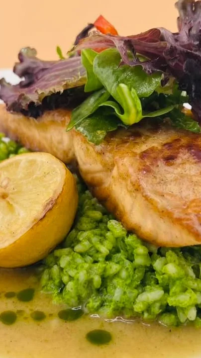 Grilled salmon with green rice and lemon, a modern seafood dish