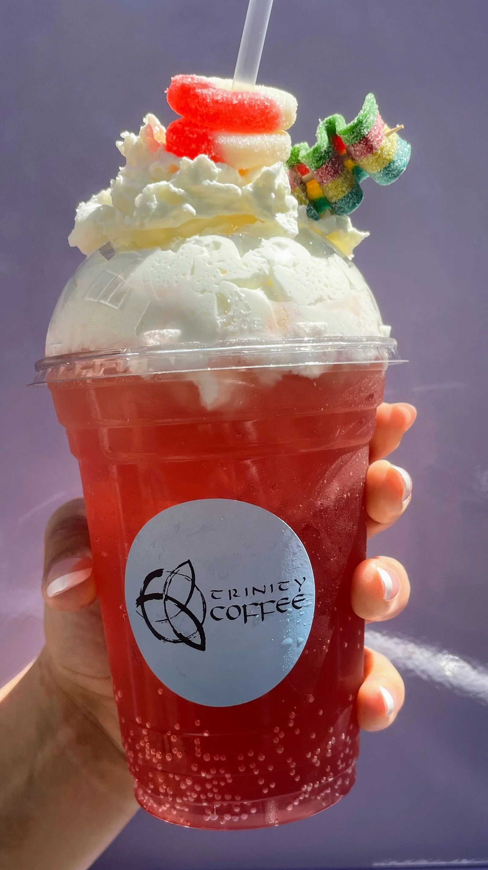 Colorful soda drink topped with whipped cream and candy
