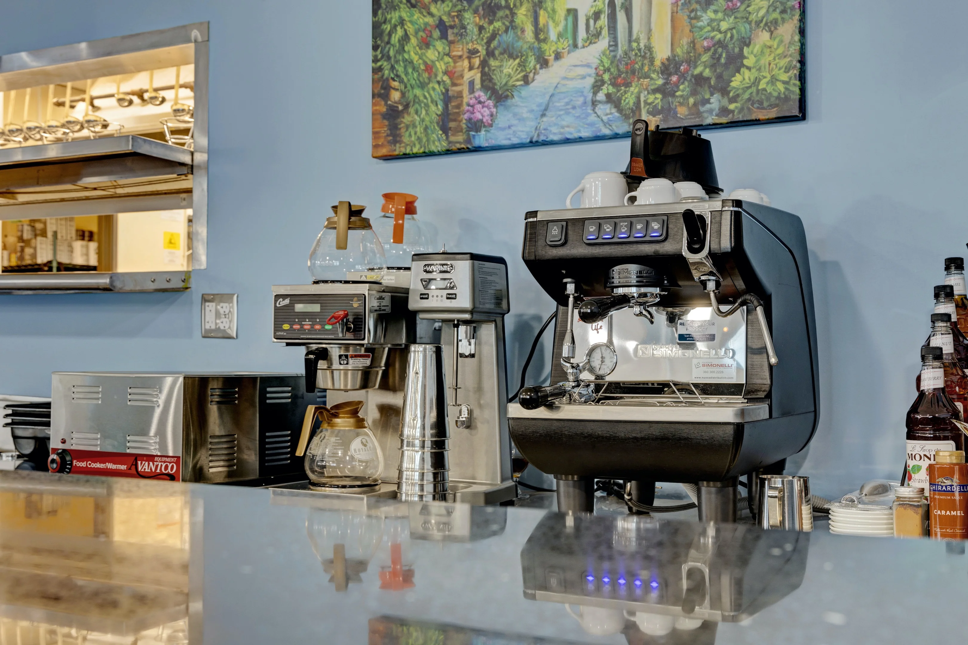 Coffee equipment and supplies in a restaurant kitchen setting.