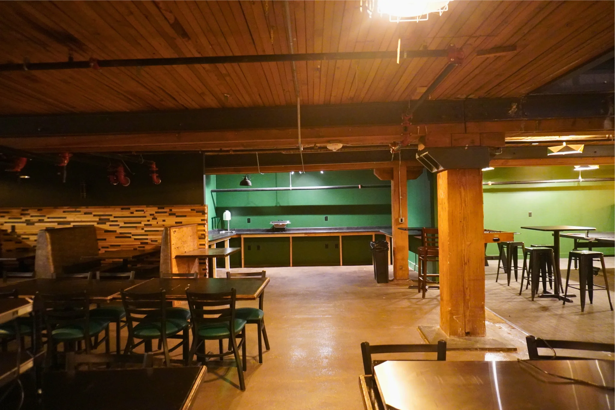 Spacious restaurant interior with wooden accents and green walls