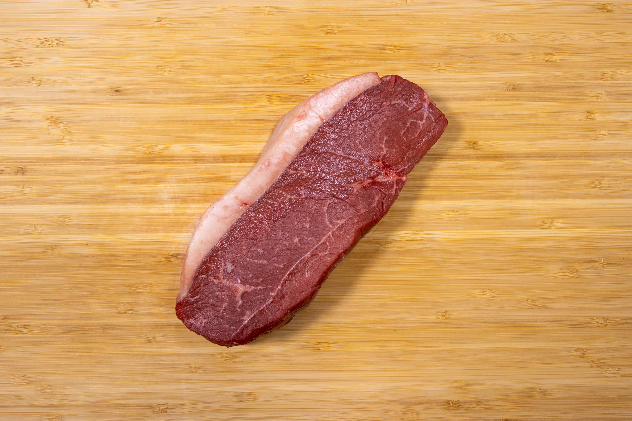 Raw beef brisket on a wooden cutting board