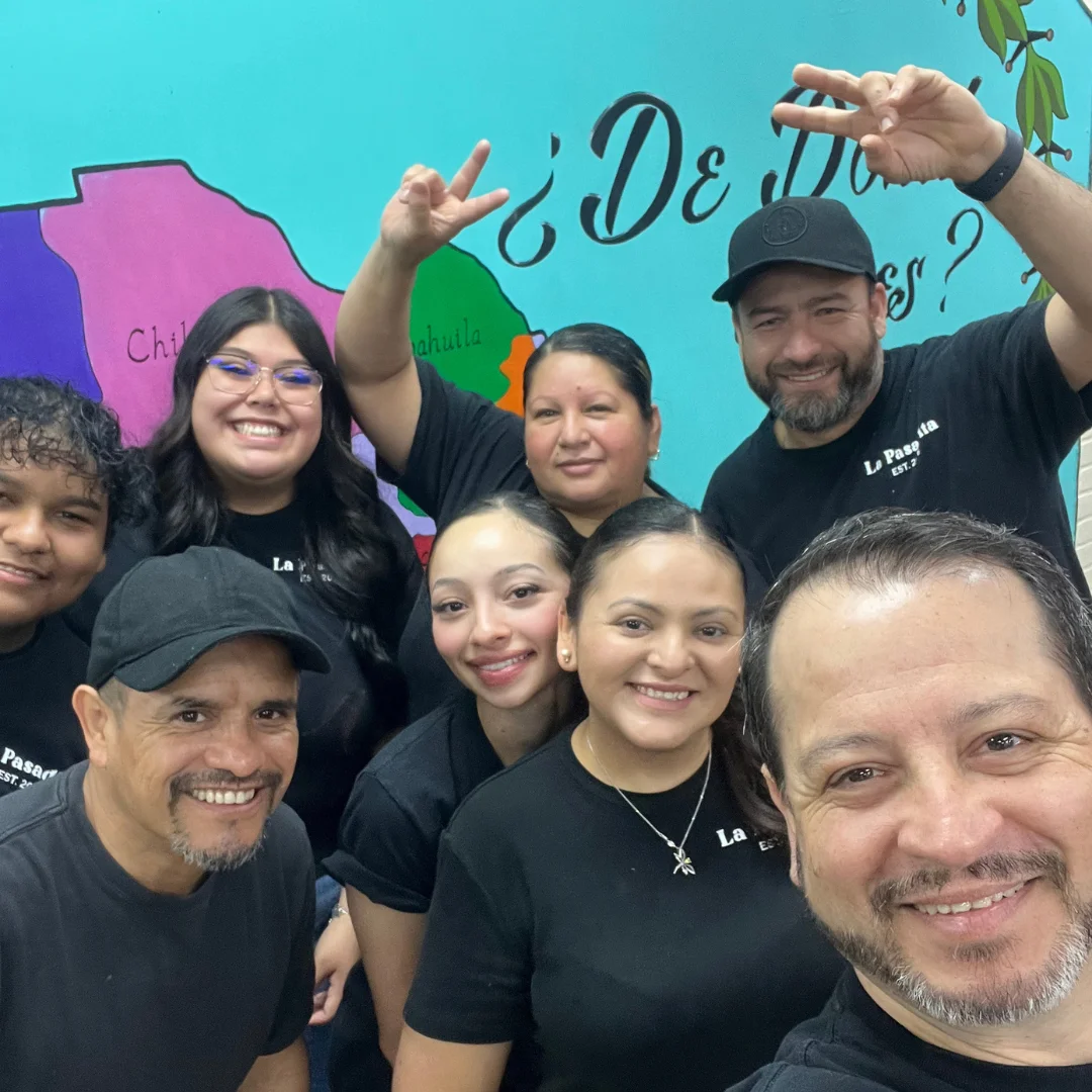Team photo at a vibrant restaurant with colorful mural