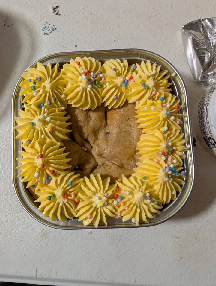 Decorative cookie cake with yellow frosting and sprinkles