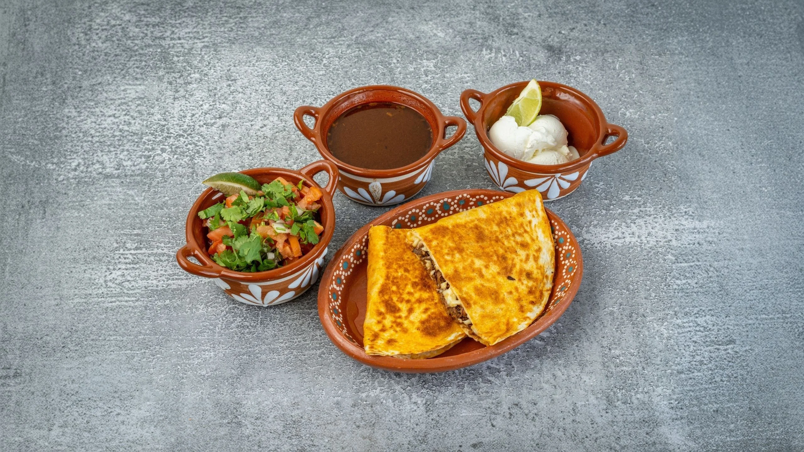 Delicious Mexican quesadilla served with salsa and crema
