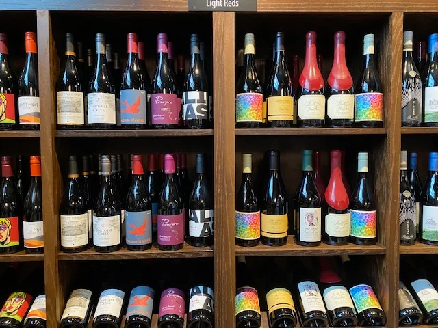 Display of light red wines on wooden shelves