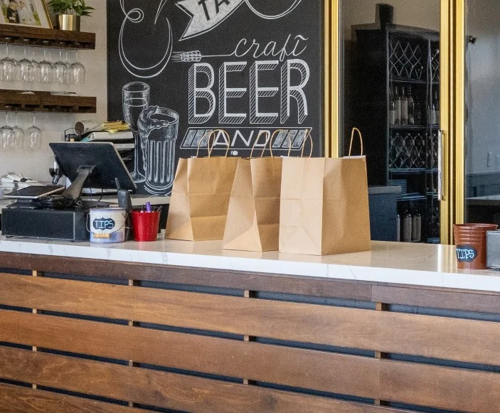 Restaurant counter with wine racks, chalkboard menu, and beverage station