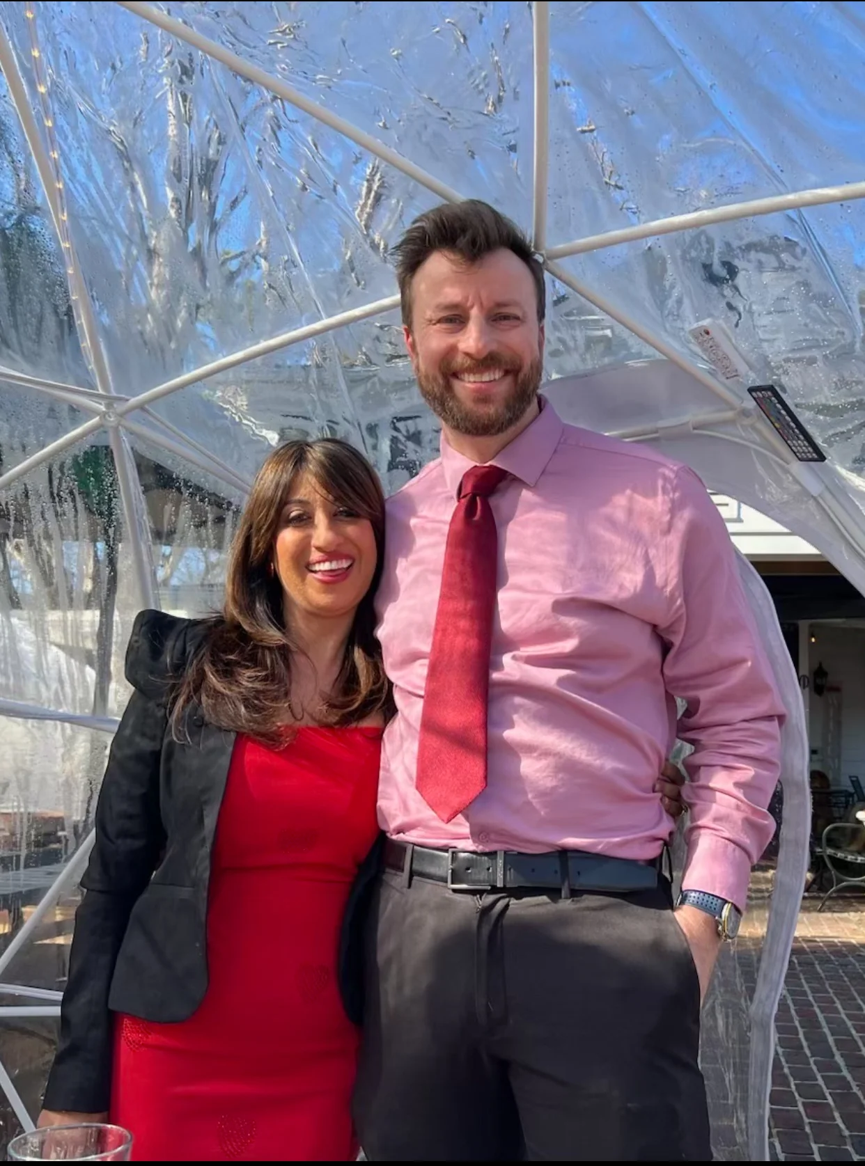 Couple posing together in a clear outdoor dining igloo